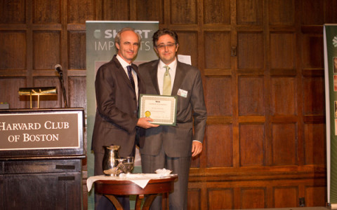Dr. Alex is presented with a  certificate of achievement
