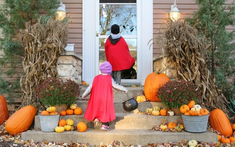 Children In Cape Costumes Trick-or-treating On Halloween